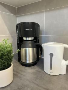 a coffee maker sitting on a counter next to a coffee pot at Appartement du Château in Lunéville