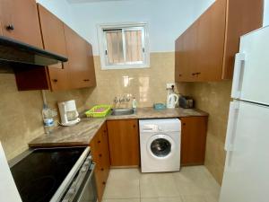 a small kitchen with a washing machine and a washer at Kontheo Elli Ground Apt 2 near the beach in Larnaka