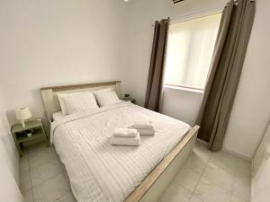 a bedroom with a bed with two towels on it at Kontheo Elli Ground Apt 2 near the beach in Larnaka