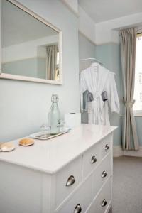 a bathroom with a white dresser with a mirror at Seaview at No. 26 Northumberland Place in Teignmouth