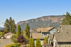 a row of houses with a mountain in the background at Falcon Suite in Cowichan Bay