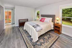 a bedroom with a bed and two windows at Cowichan Valley Country Escape in Cobble Hill