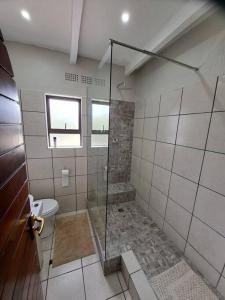a bathroom with a shower and a toilet at Angel's Rest in Port Alfred