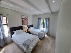 a bedroom with two beds and a window at Angel's Rest in Port Alfred