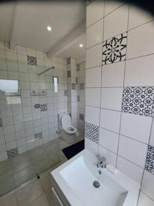 a bathroom with a sink and a shower and a toilet at Angel's Rest in Port Alfred