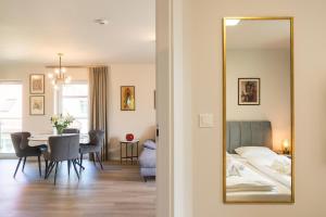 a room with a mirror and a table and a bed at Polanica Residence and SPA, MyWeek in Polanica-Zdrój