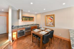 cocina con mesa, sillas y barra en Salishan Chief Suite, en Cowichan Bay