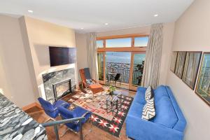 a living room with blue chairs and a fireplace at Salishan Chief Suite in Cowichan Bay