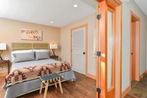 a bedroom with a bed and a stool in it at Salishan Chief Suite in Cowichan Bay