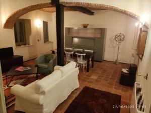 een woonkamer met witte banken en een tafel bij Appartamenti presso Cascina La Melagrana in Costigliole dʼAsti