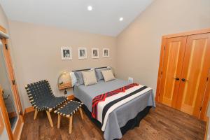 a bedroom with a bed and two chairs in it at Salishan Tree House Suite in Cowichan Bay