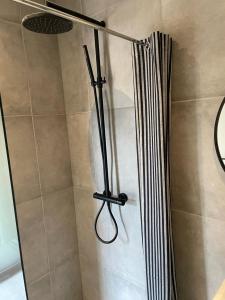 um chuveiro na casa de banho com uma cortina de chuveiro em SØGAARDEN - Hotel & SøCamp em Sunds