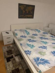 a bed with a blue and white comforter on it at Vila primitoare in apropiere de aeroport in Ghiroda