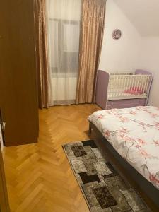 um quarto com uma cama e um berço num quarto em Vila primitoare in apropiere de aeroport em Ghiroda