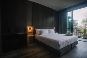 um quarto com uma cama grande e uma janela grande em INN BLOG HOTEL Pakbara em Satun