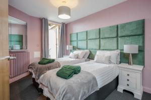 a bedroom with two beds with green pillows on them at Perfect for visiting the Excel, O2, Canary Wharf - 15 mins from London City Airport in London