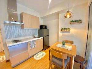 cocina con mesa y cocina pequeña con mesa y sillas en Homey & Comfy 1BR Unit at Azure, en Manila