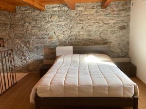 a bed in a room with a stone wall at La Maison du Cre in Valtournenche