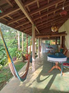 eine Hängematte, die von einer Veranda eines Hauses hängt in der Unterkunft Natural Mystic Sanctuary in Deniyaya