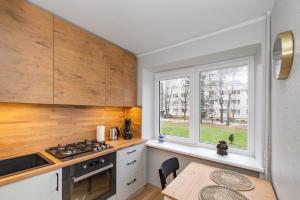 eine Küche mit einem Tisch und einem Fenster in der Unterkunft Modern n' lovely apartment by Polo Apartments in Kaunas