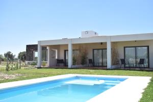 a swimming pool in front of a house at Villa Mendotza in Ciudad Lujan de Cuyo