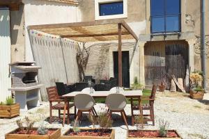 a patio with a table and chairs in a yard at Loft Chocolatine, spacieux, piscine, trampoline in Carcassonne