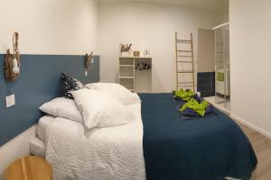 a bedroom with a bed with pillows and a blue wall at Loft Chocolatine, spacieux, piscine, trampoline in Carcassonne
