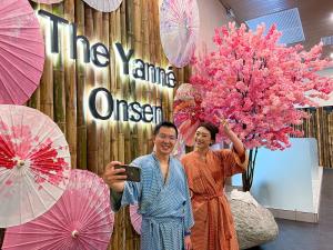 two women standing in front of a wall with umbrellas at The Yanné, Onsen Hotel in Genting Highlands