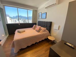 1 dormitorio con cama y ventana grande en Duas suítes com vista deslumbrante em Ipanema, en Río de Janeiro
