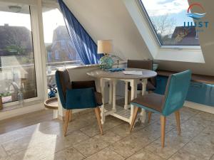 a dining room with a table and chairs and a window at Haus Atelier Appartement 101 - Wohnung 4 in Juist