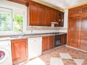 cocina con armarios de madera y lavavajillas blanco en Nerja - Casa Vivi 8, en Nerja