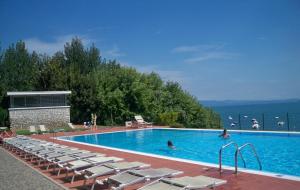 a large swimming pool with lounge chairs and the water at Gardazzurro in Padenghe sul Garda