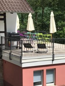 a balcony with chairs and umbrellas on a building at Grundmühle Rhön in Nordheim vor der Rhön