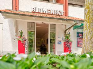 a building with flowers in front of a flower shop at Appartement-Haus Blumenhof in Bad Griesbach