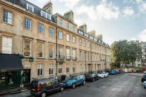 a street with cars parked in front of a large building at Ivy House in Bath