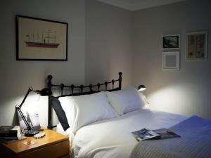 a bedroom with a bed and a table with a lamp at Flamingo House in Whitstable