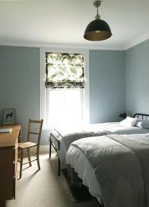 a bedroom with a bed and a desk and a window at Flamingo House in Whitstable