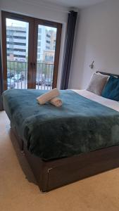 a large bed in a bedroom with a large window at St Albans - Luxury 1 Bedroom Apartment in Saint Albans