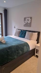 a bedroom with a large bed with a blue blanket at St Albans - Luxury 1 Bedroom Apartment in Saint Albans