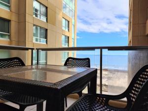 a table and chairs on a balcony with a view at Project BNB at The Bay in Glenelg