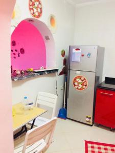 a kitchen with a table and a refrigerator with a pizza at Small apartment with Garden in Cairo