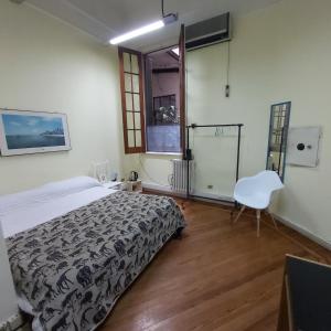 1 dormitorio con 1 cama y 1 silla en Cerca de todo Habitaciones en Buenos Aires