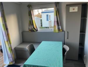 ein Esszimmer mit einem Tisch und einem Fenster in der Unterkunft Auberge des Etangs in Roussent