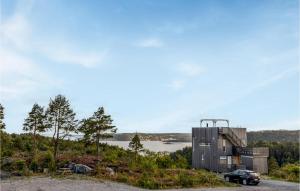 a house on a hill with a car parked next to it at 3 Bedroom Cozy Home In Søndeled in Søndeled