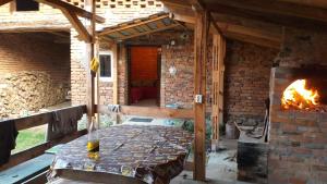 a room with a brick oven with a table and a fireplace at Studio cu bucatarie , baie , scara interioara , etaj cu dormitor openspace , curte cu grill, terasa in Borlova