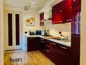 a kitchen with red cabinets and a sink at Casa Cenami in Lucca