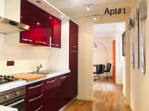 a kitchen with red cabinets and a sink at Casa Cenami in Lucca