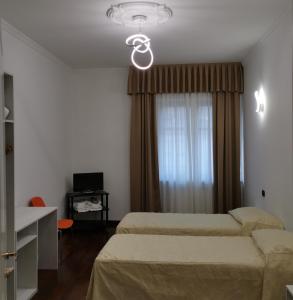 una camera d'albergo con due letti e una finestra di Guest house Central Station a Milano