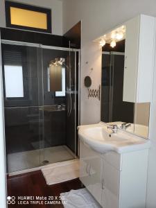 a bathroom with a glass shower and a sink at Guest house Central Station in Milan