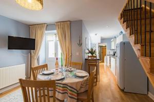a kitchen and dining room with a table and chairs at Curious Cottage in Deal